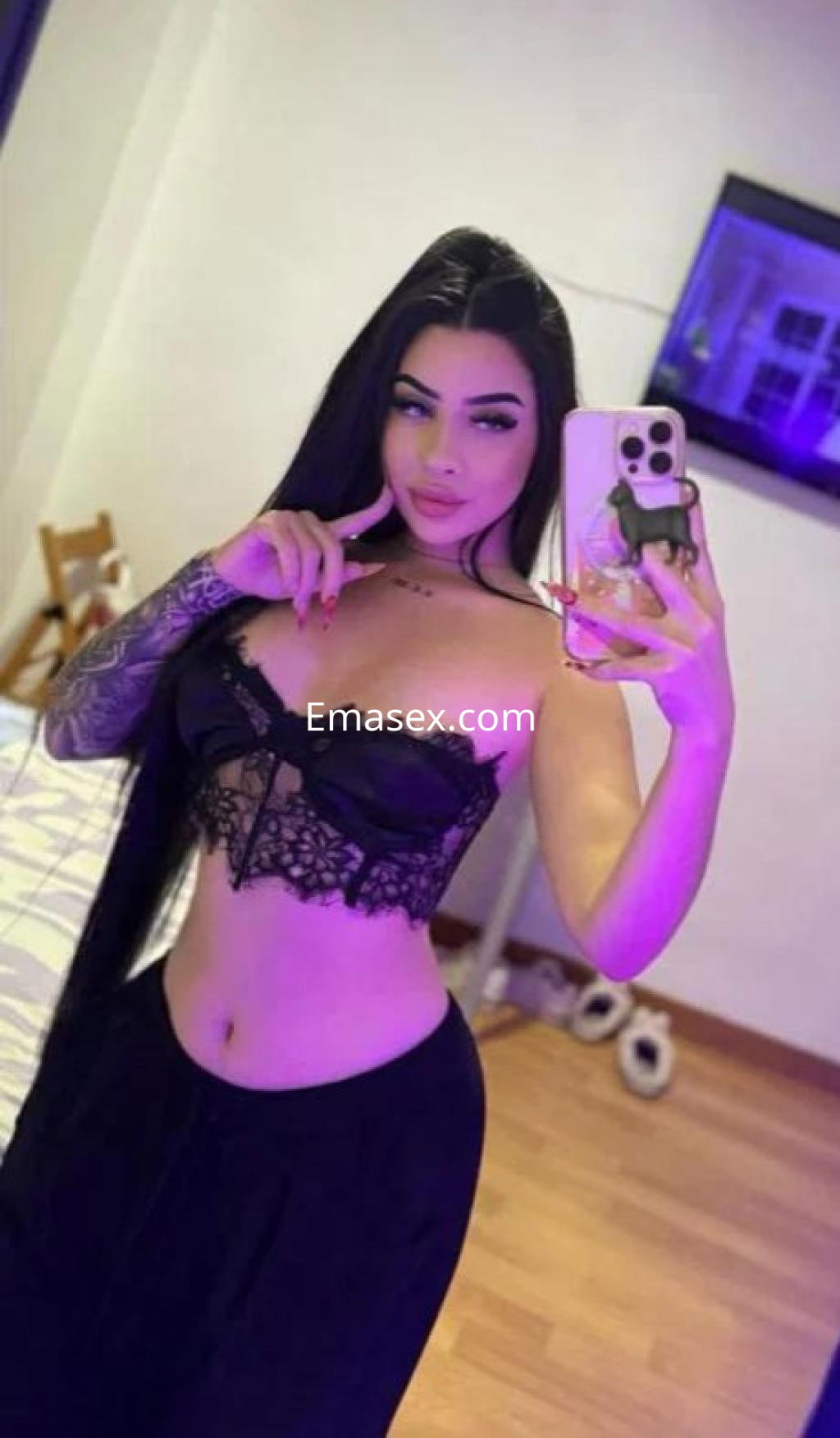 Puta en Granada con cabello largo y lacio, viste un conjunto negro de encaje y pantalones ajustados mientras se toma una selfie.
