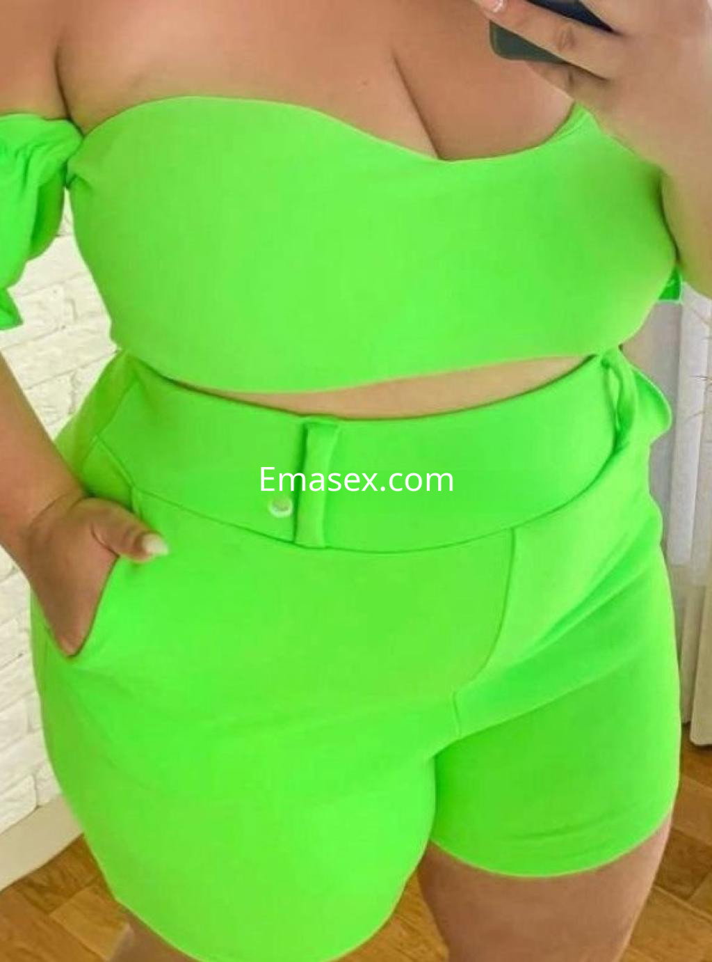 Puta en Vigo luciendo un conjunto ajustado en color verde neón, con top sin mangas y pantalones cortos.
