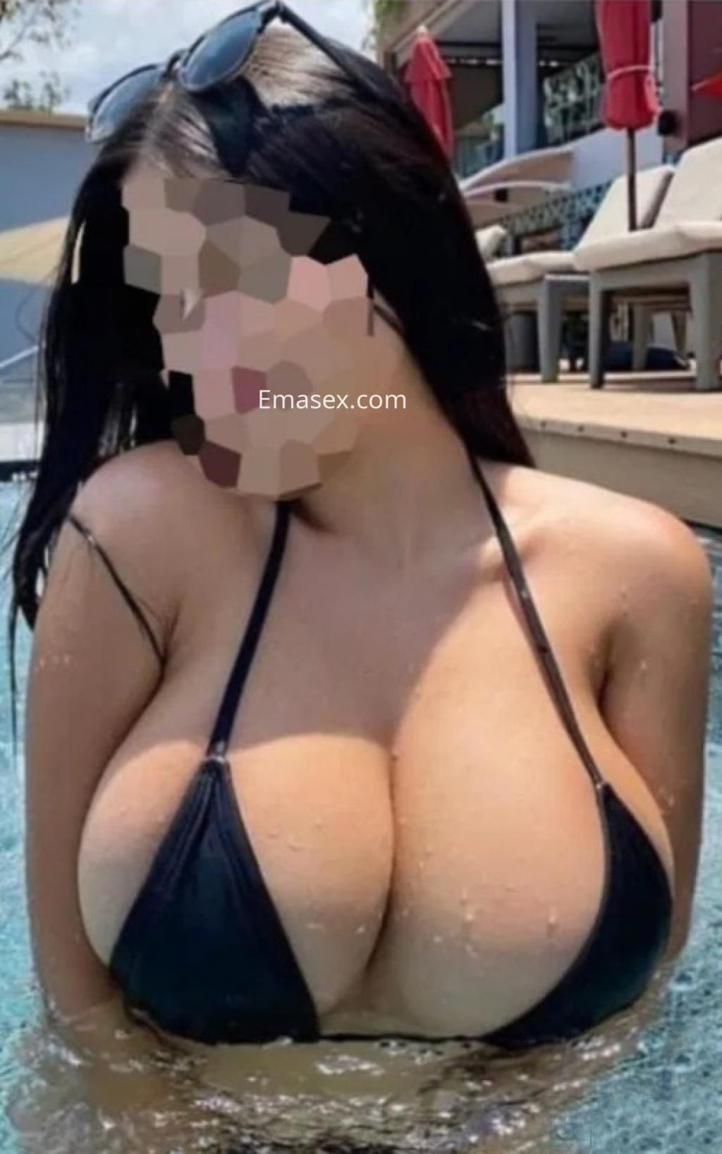 Escort con cabello largo y oscuro, lleva un bikini negro mientras se encuentra en una piscina en Coruña.