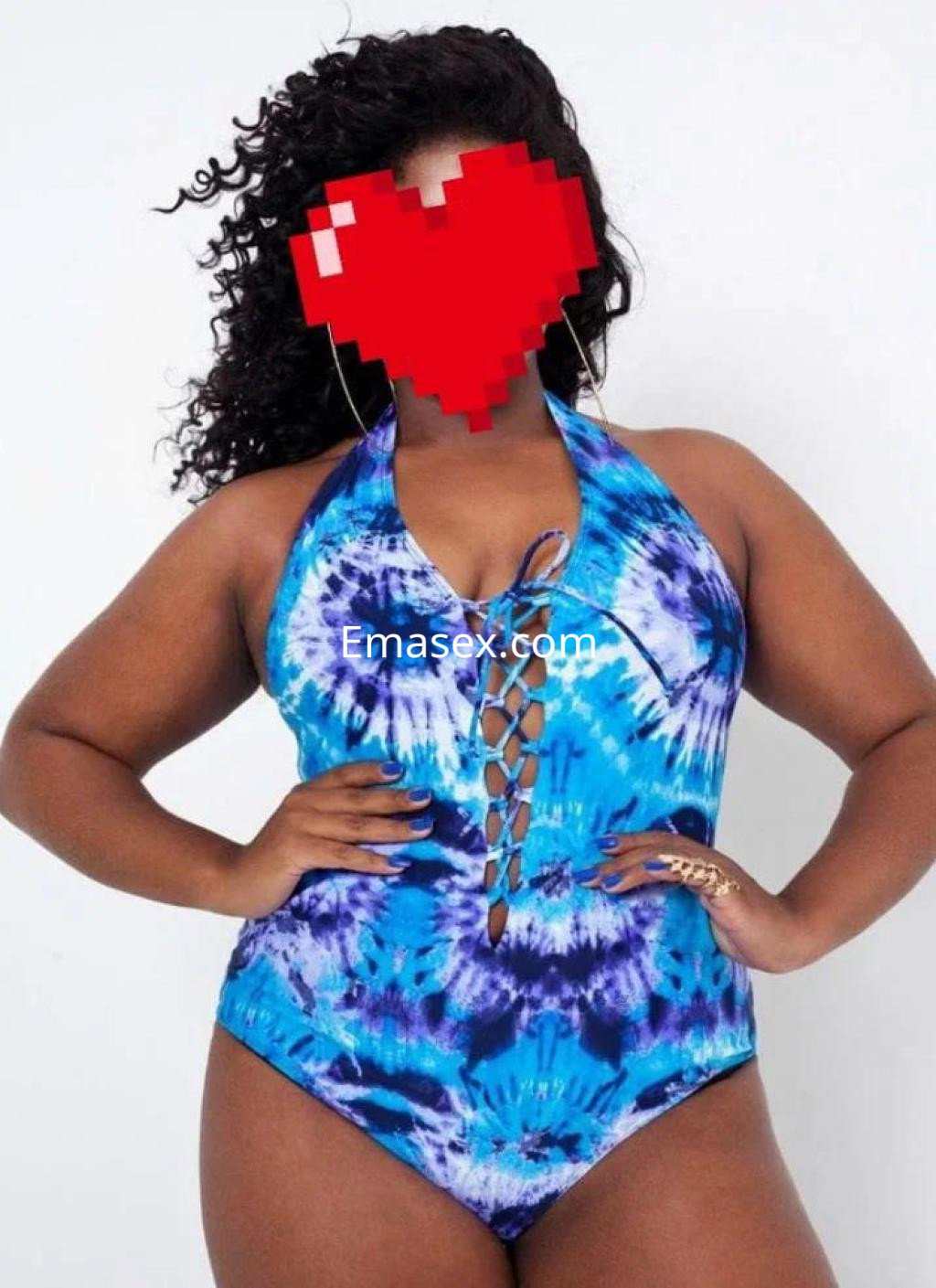 Escort de piel morena, con cabello rizado, viste un bañador azul con estampado tie-dye en Ourense.