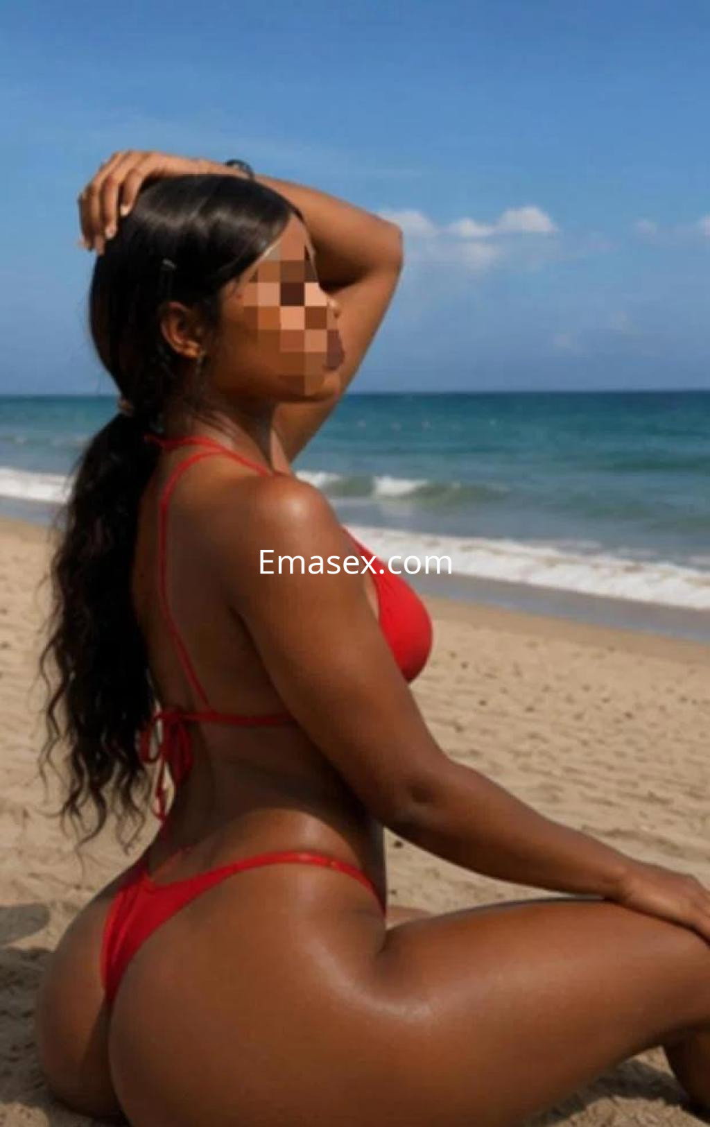 Escort posando en la playa de Ourense, con un bikini rojo y el cabello largo suelto, frente al mar.