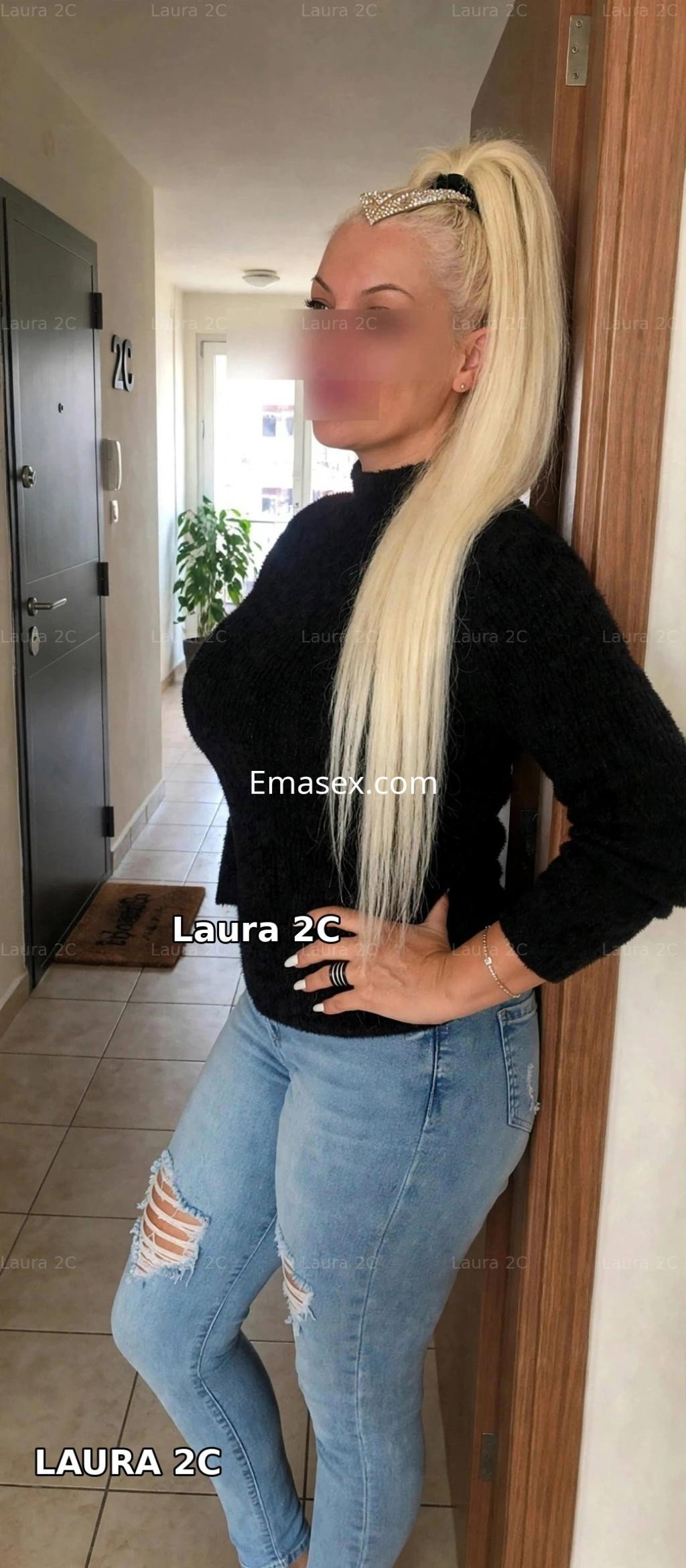 Puta de cabello rubio y largo, vestida con suéter negro y jeans rotos, posando en un pasillo en Donosti.