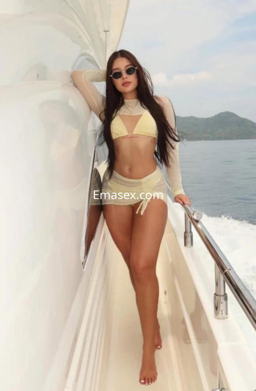 La puta posa en un yate en Palma de Mallorca, luciendo un bikini amarillo y gafas de sol, mostrando confianza.