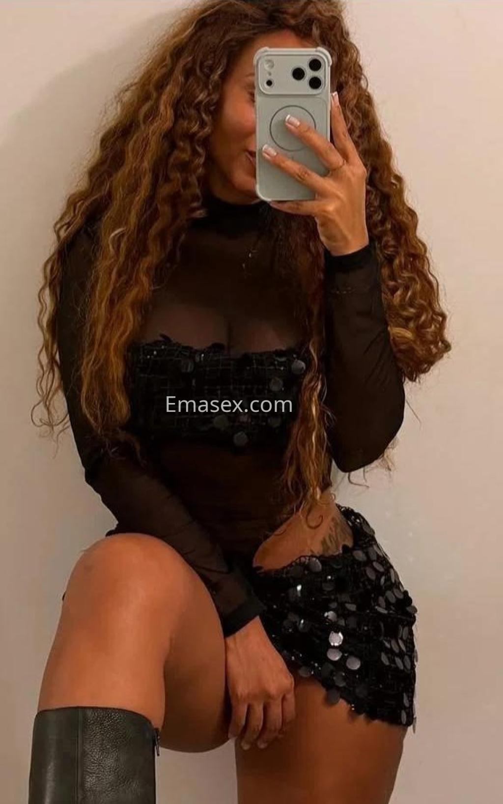 La puta se toma una selfie en Toledo, vistiendo un top negro transparente y una minifalda con lentejuelas.